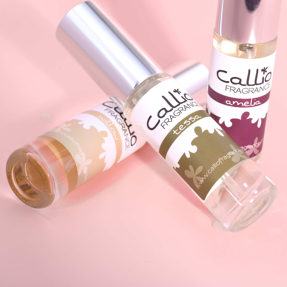 Willow, Tessa, and Amelia travel sprays on a pink background.